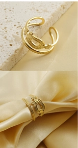 Detail of adjustable 18k gold stainless steel ring with horseshoe buckle design