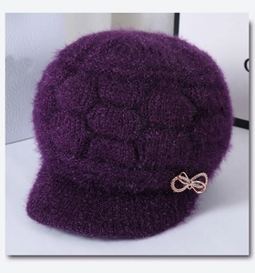 Detail of purple knitted winter hat with rhinestone butterfly and honeycomb pattern
