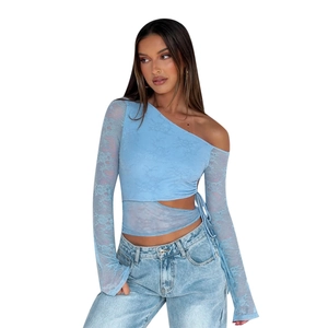 Dettaglio ravvicinato del tessuto in pizzo azzurro con elegante nastro laterale annodato