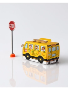 Macro shot of yellow school bus paper candy box with stop sign on white background