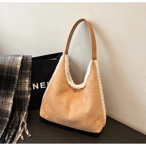 Detailed macro view of the fuzzy fleece trim and brown suede texture on the hobo tote bag