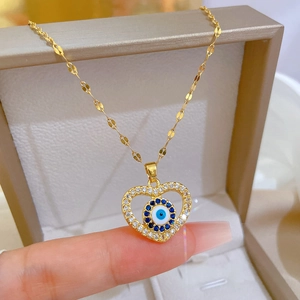 Gold titanium steel heart necklace featuring an evil eye pendant with blue crystals
