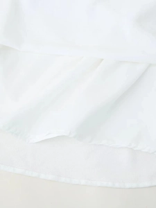 Gros plan d'une robe blanche avec tissu superposé de qualité et détails de couture