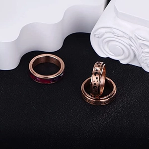 Three-piece rose gold fidget ring set featuring sun moon star relief and marble inlay