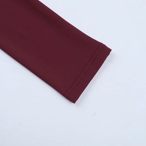 Détail de la manchette d'une robe bordeaux avec des coutures à double aiguille de qualité