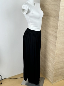 Detail view of high-waisted black pleated maxi skirt paired with a white T-shirt