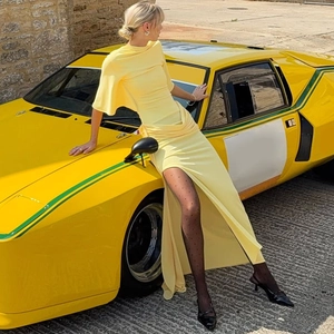 Detail of yellow backless dress with side slit and draped ribbon for summer fashion