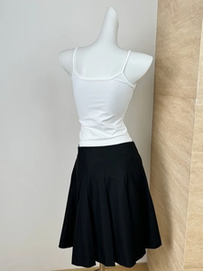 Rear view of black pleated midi skirt with white tank top on a female mannequin