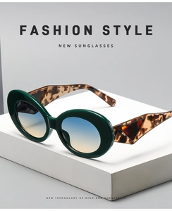 Detail of oval sunglasses with green frames, tortoiseshell temples and gradient lenses