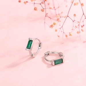 Elegant S925 silver hoop earrings with emerald green zircon on pink background