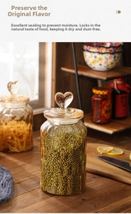 Detail of amber glass storage jar with heart handle filled with green beans on kitchen counter