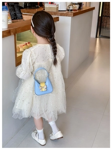 Detail of blue PU leather kids crossbody bag with gold bow and metal chain strap