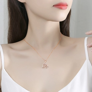 Rose gold heart pendant necklace with Mom engraving and diamonds worn by a model