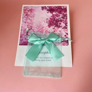 Close-up of mint green organza gift bag with a satin ribbon bow for jewelry packaging
