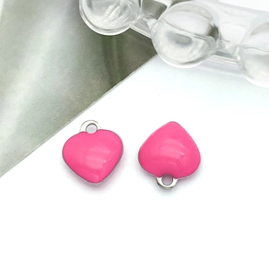 Macro shot of bright pink enamel heart charms with silver metal rings for DIY jewelry making