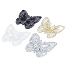 Vue détaillée de quatre écussons papillons en dentelle avec paillettes en noir, beige et blanc
