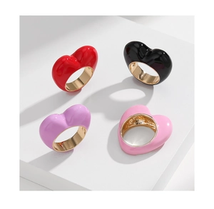 Detail of colorful 3D heart enamel rings on white display stands with gold plating