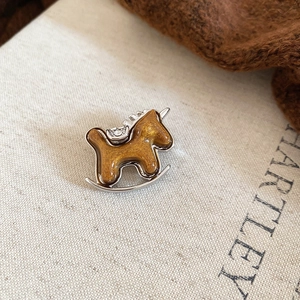 Macro shot of retro horse brooch with gold glitter finish and sparkling rhinestones