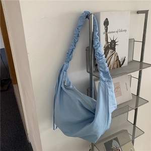 Dettaglio della borsa hobo in nylon celeste con tracolla increspata e cerniera in metallo argento