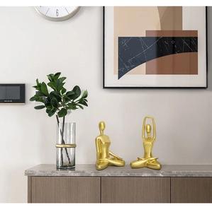 Close-up of golden yoga figurines on a marble desk in a luxury Nordic style room