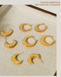 Detailed view of gold plated C-shaped earrings with wave, star, and honeycomb textures