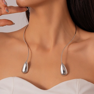 Vue détaillée du collier ras de cou argenté en forme de goutte porté par un mannequin