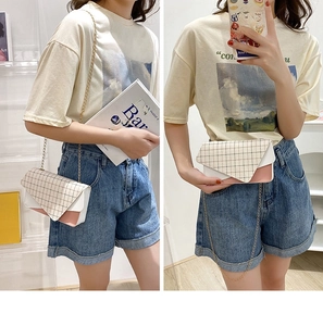 Detailed view of tricolor envelope crossbody bag with plaid flap and gold chain strap