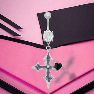 Détail d'un piercing nombril avec pendentif croix et pierre en cœur noir