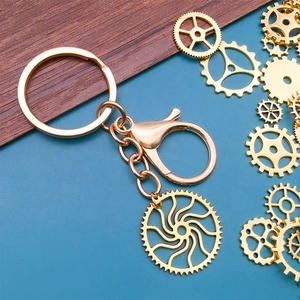 Steampunk style golden alloy mechanical gear keychain pendant on blue background