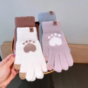 Close-up of winter knit gloves in four colors featuring cute cat paw prints and plush texture