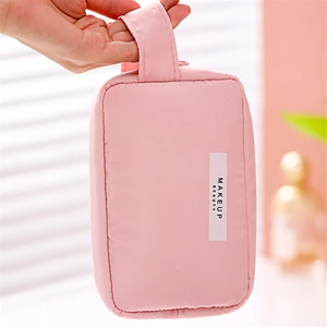 Détail de la poignée et de l'étiquette brodée MAKEUP BEAUTY de la trousse de toilette