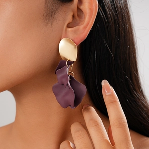 Close-up of a purple irregular acrylic flower earring with gold stud worn by a model