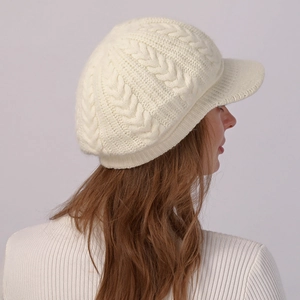 Detalle de punto trenzado en una gorra de punto beige con visera para el invierno