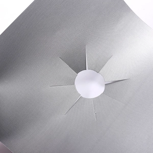 Detailed close-up of a silver Teflon gas stove protector with a star-shaped cutout detail