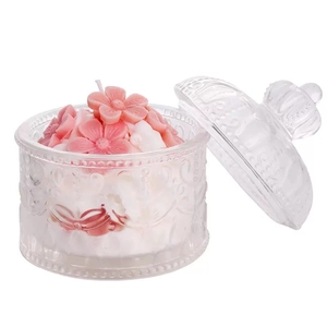 Pink floral cake scented candle in embossed glass jar on white background