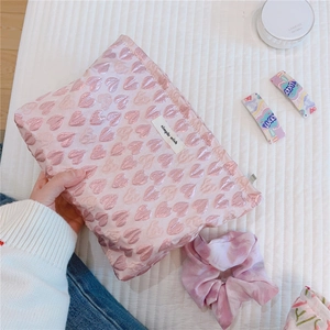 Detail of pink jacquard fabric makeup bag with heart embroidery and simple wish tag