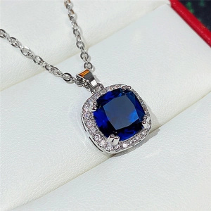 Detail of silver necklace featuring a square royal blue glass pendant with small crystals