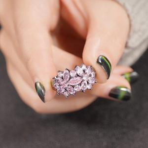 Close-up of pink marquise-cut gemstone flower ring on a black metal band