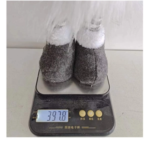 Luminous Christmas plush doll showing grey fuzzy boots on a scale weighing 397.8 grams
