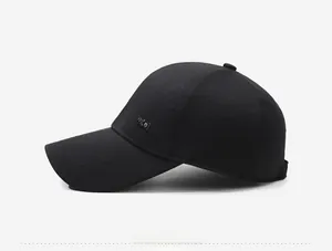 Zijaanzicht van de zwarte twill baseballpet met fijn stiksel en metalen merkplaatje
