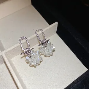 Ohrringe mit Blumenmuster, Strass und Perlen in einer weißen Schmuckschatulle