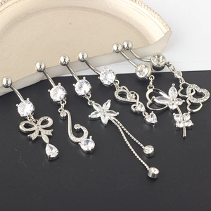 Detailed macro view of 5 silver belly rings with crystal star, heart and butterfly motifs