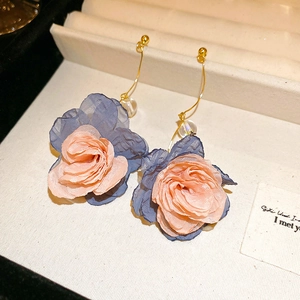 Close-up of pink and blue fabric flower tassel earrings with golden hooks on display