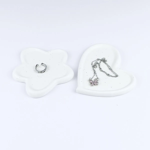 Minimalist matte white heart and flower jewelry tray set holding rings and a necklace