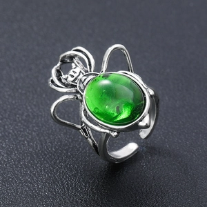 Macro detail of gothic spider ring featuring a vintage silver finish and green gemstone