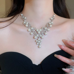 Detail shot of French style waterdrop pearl and diamond necklace worn by a model