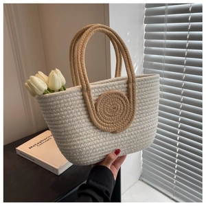 Detail of woven cotton rope handbag featuring khaki spiral design and tulip decoration