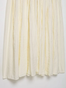 Dettaglio dell'abito in pizzo crema con elegante texture a pieghe e drappeggio