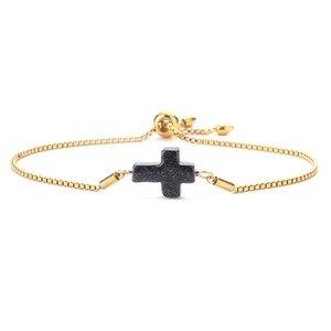 Detail of adjustable gold box chain bracelet featuring a blue sandstone cross charm