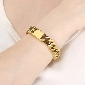 Gros plan sur un bracelet gourmette doré serti de diamants avec une plaque rectangulaire